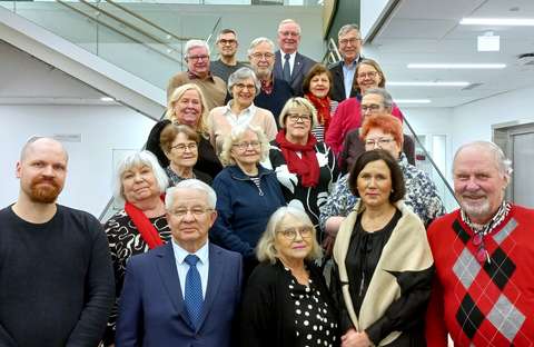 Kuvassa vanhusneuvoston jäsenistö poseeraa portaikossa.